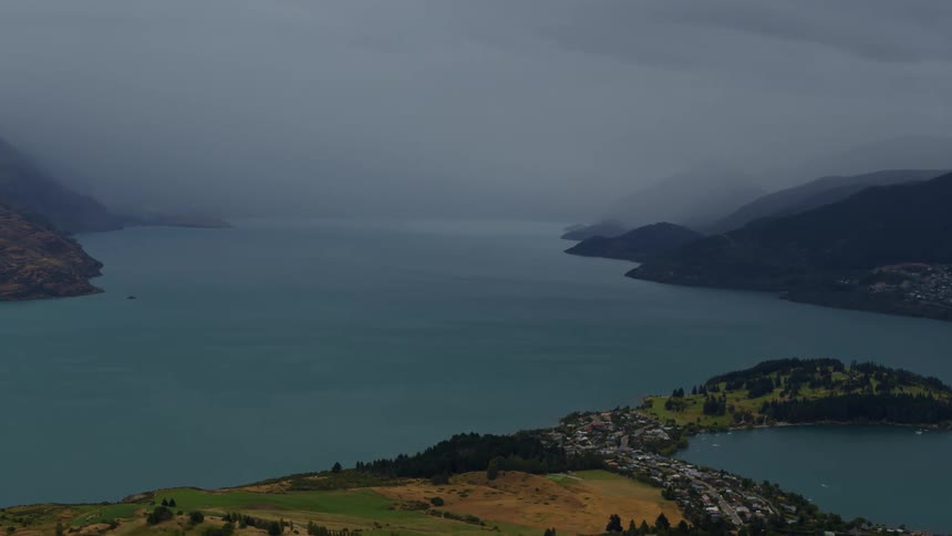 A small town on the edge of a lake with approaching weather