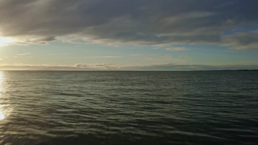 Aerial view of body of ocean water at sunset