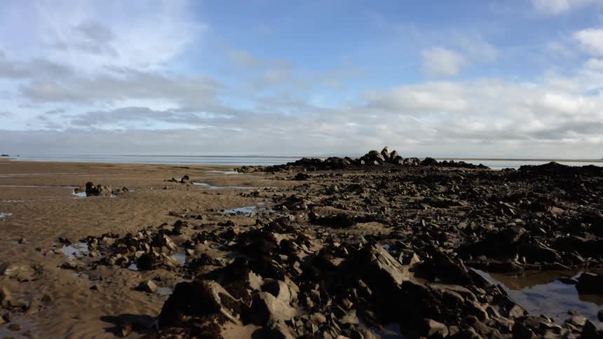 A rocky shoreline on a blue calm day
