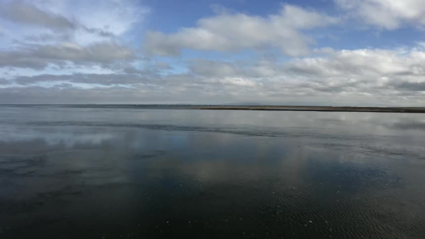 Reflective aerial view of still body of water and coast
