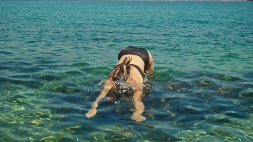 A woman is swimming in the water during the spring
