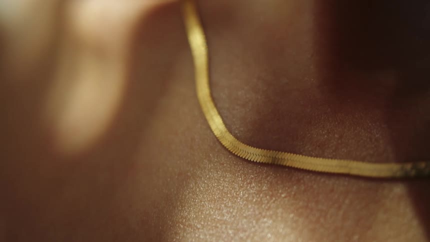 A person is wearing a gold necklace
