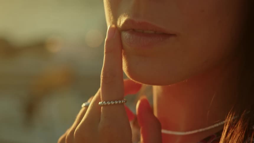 A woman poses with her hands clasped to show off her rings