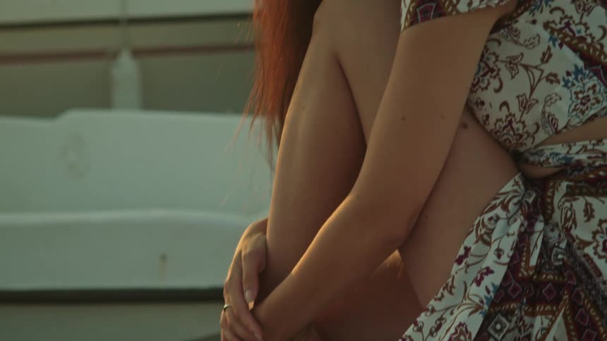 A woman sitting on a dock smiles