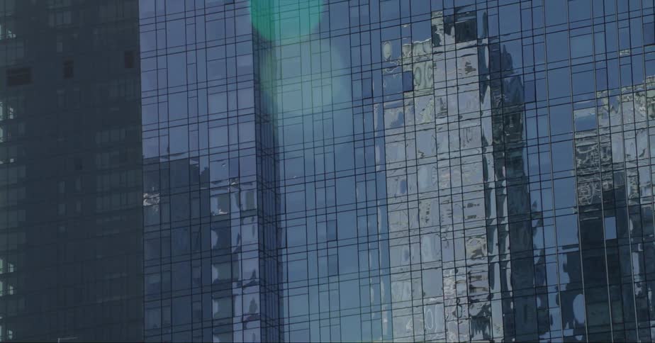 Skyscrapers reflecting on the windows of a tall building in the city skyline