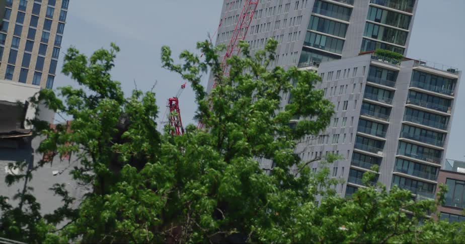 A construction crane in a city skyline next to skyscrapers
