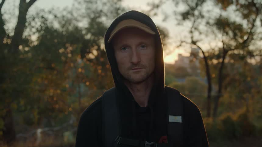 A man is standing outdoors during the season of autumn