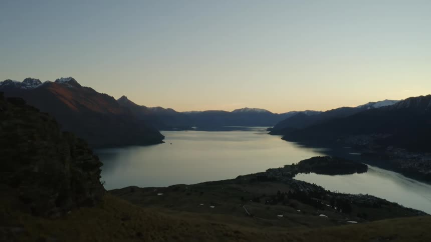Aerial view of the sun setting in the horizon reflected in the lake