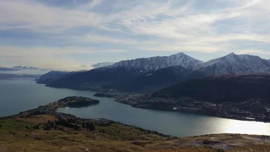Aerial view of a small town on the edge of a lake next to the mountains
