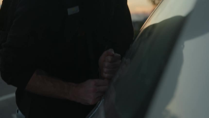 Man with black hoodie backpack and jeans breaks into car using poker