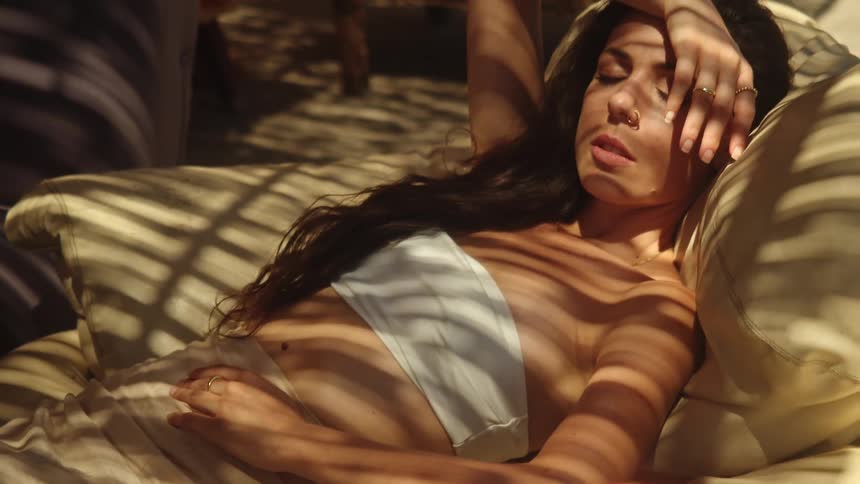 A woman is laying on a couch and resting