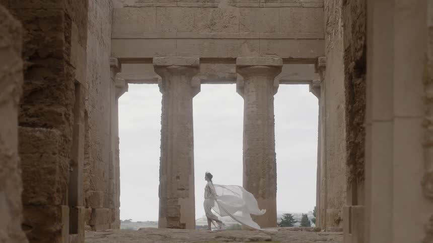 A woman walks past two pillars