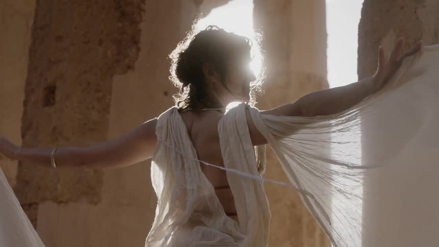 A woman has her arms stretched out before lowering them