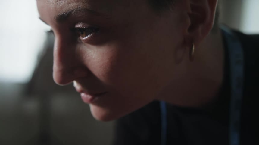 A woman leans forward while looking at something
