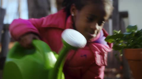A girl waters a plant