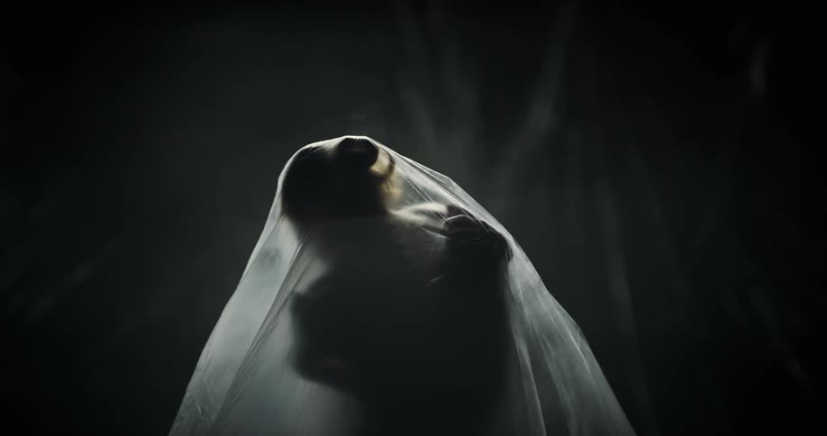 A woman is moving under the plastic sheet