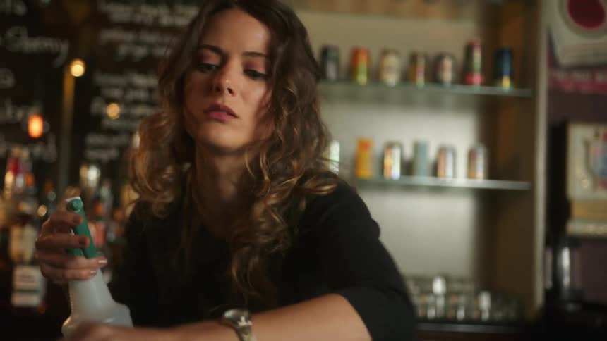 A woman is wiping down the bar counter