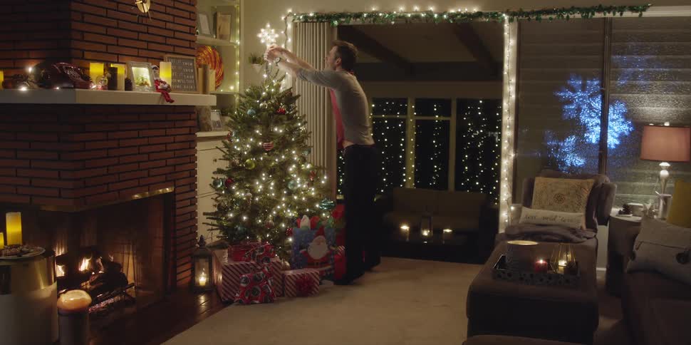 A man places presents under the christmas tree