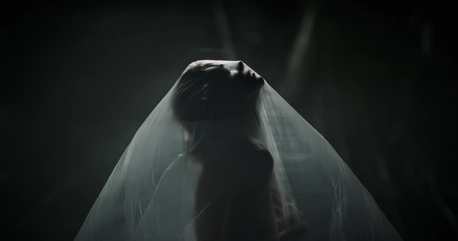 A woman moves under the plastic sheet