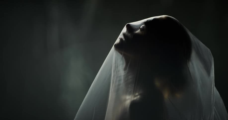 A woman turns her head under the plastic
