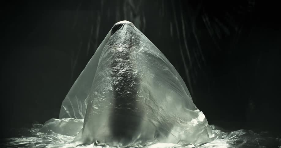 A person is under the large plastic sheet