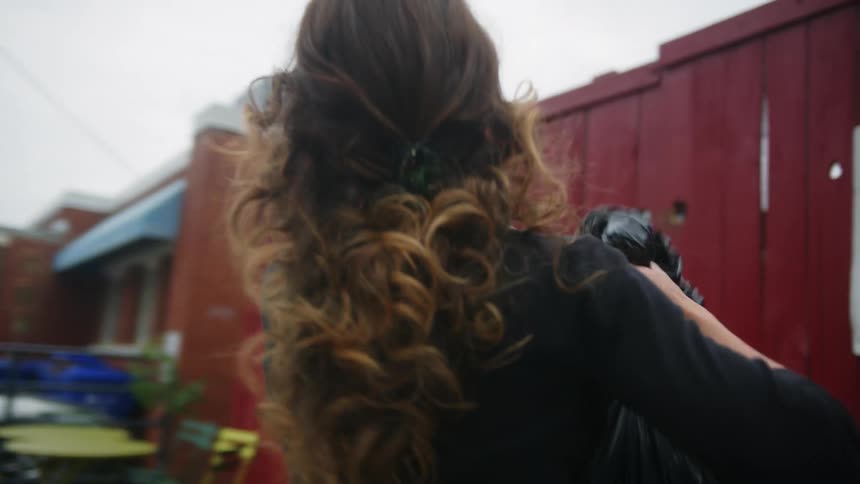A woman takes out the garbage