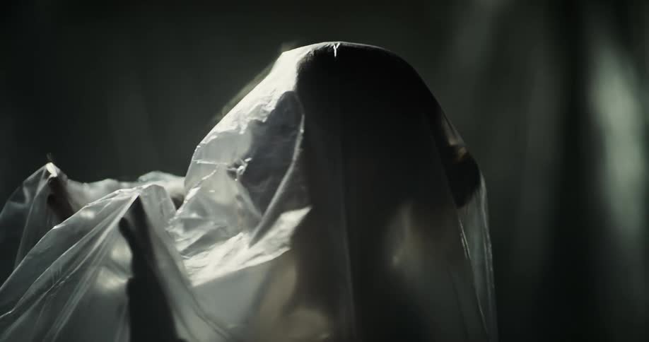 A woman is reaching her hands under the plastic sheet