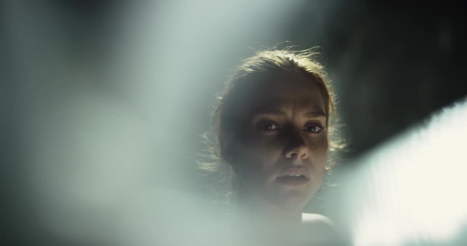 A woman turns her head in the dark