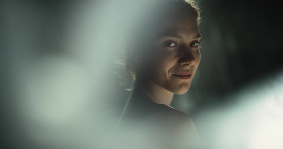Woman looks up and smiles partly covered by light fog