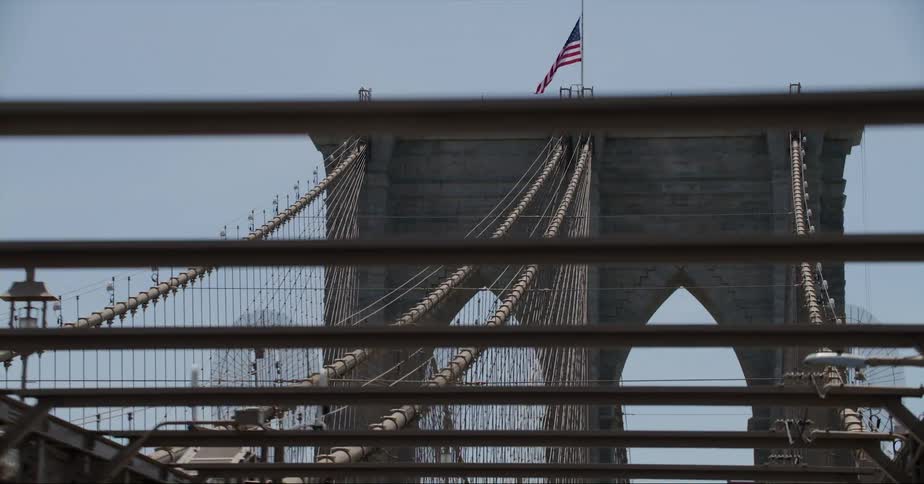Close up of suspension bridge with a us flag on top