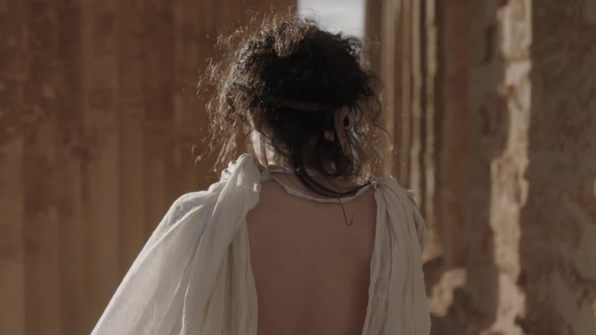 A woman wraps her robe around her shoulder