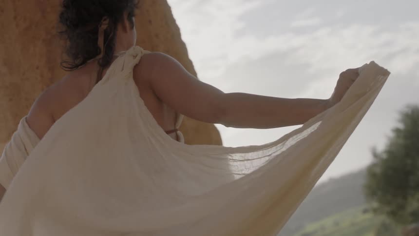 A woman is walking with her arms stretched out