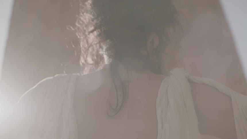 Woman in white dress stands and waits