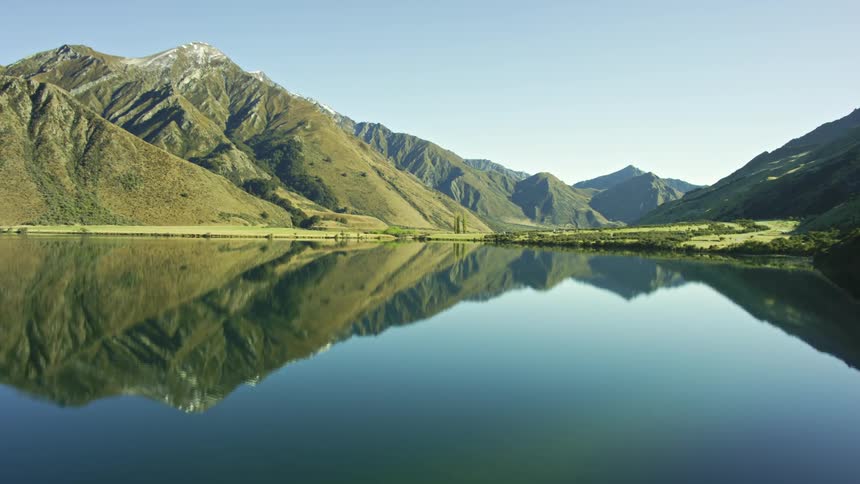 Mountains reflect off crystal clear water in the lake below