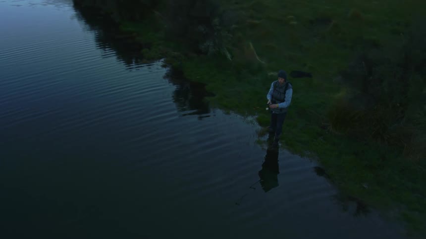 A man is fishing at the alpine lake