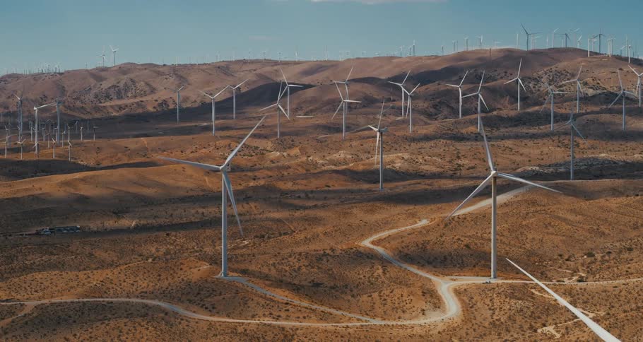 Aerial view of a rural area with wind mills is displayed