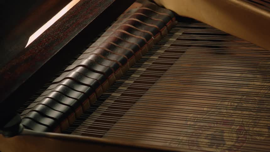 Piano wire moves with the keys in a wooden piano