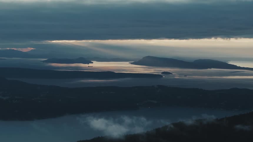 Clouds floating by as an oil tanker sails in the distance