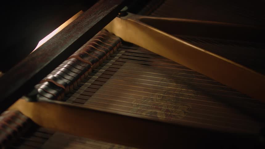 Hammer mechanism strikes strings as piano is played
