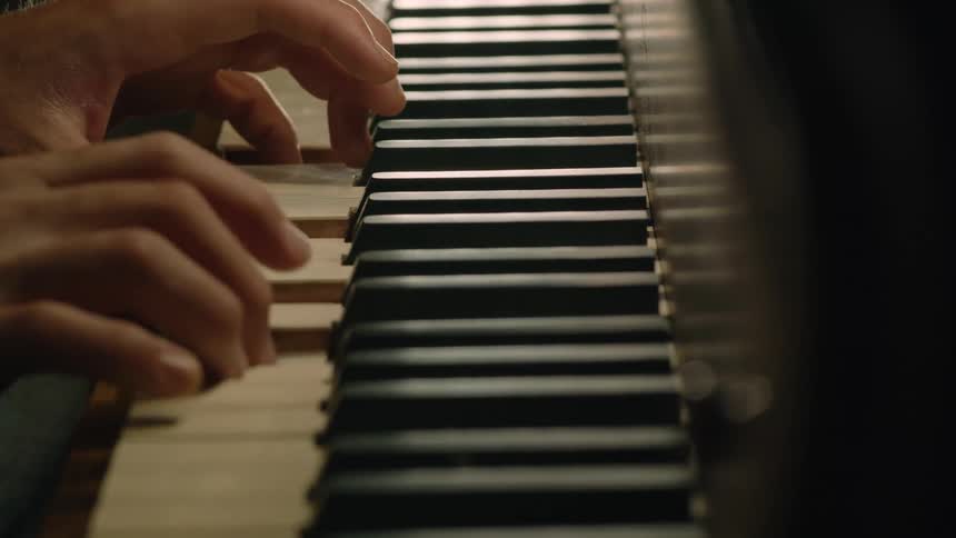 Pianists hands plays a piano keyboard