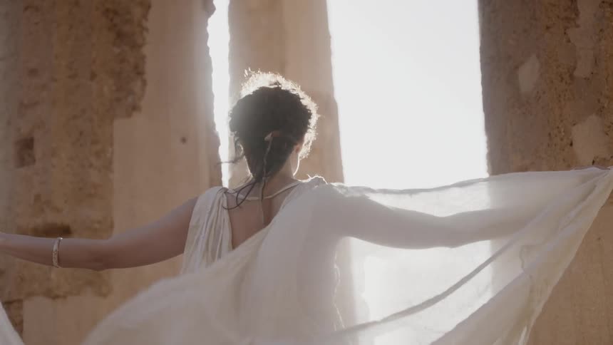 A woman stretches her white robes in the wind