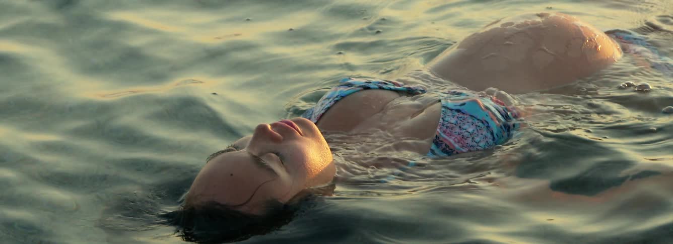 A pregnant woman is resting in the ocean water