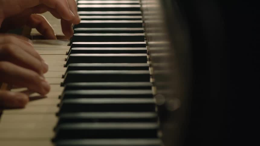 A person is playing the piano by themselves