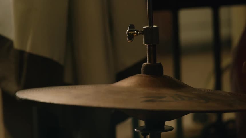 A cymbal on a set of drums as a person plays