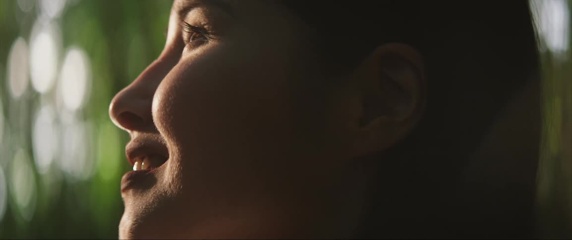 Side profile of woman opening eyes and smiling
