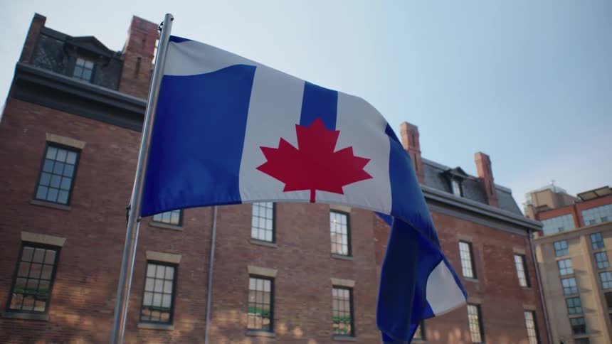 Toronto flag waving in the wind in the city at morning