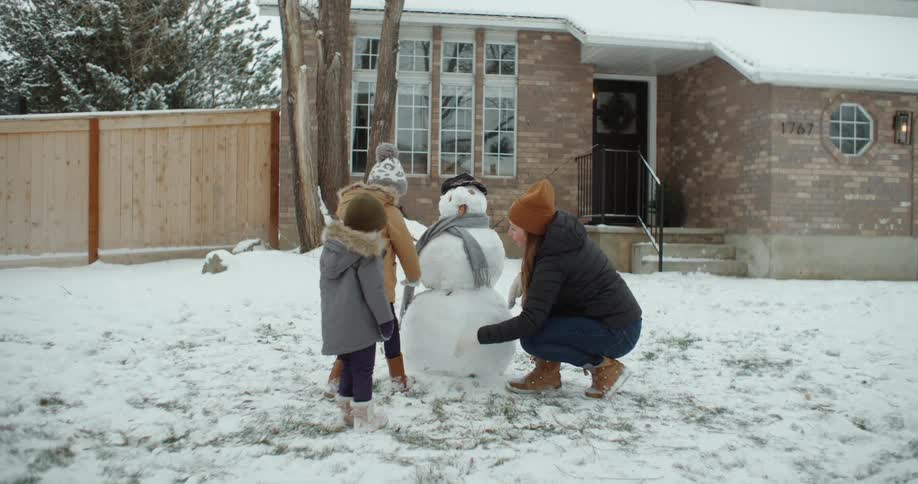 A family build a snowman together