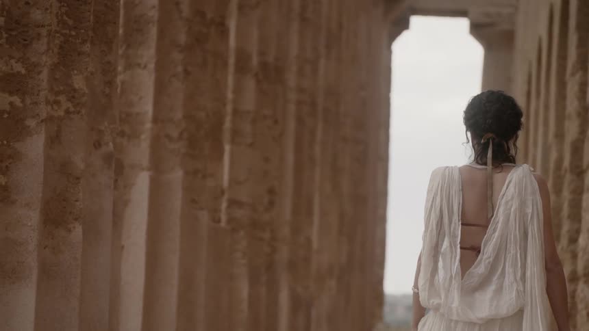 A woman walking along the front of the acropolis