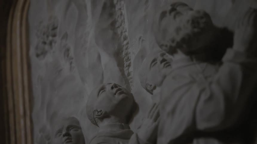 A carving of  three men in a dark room