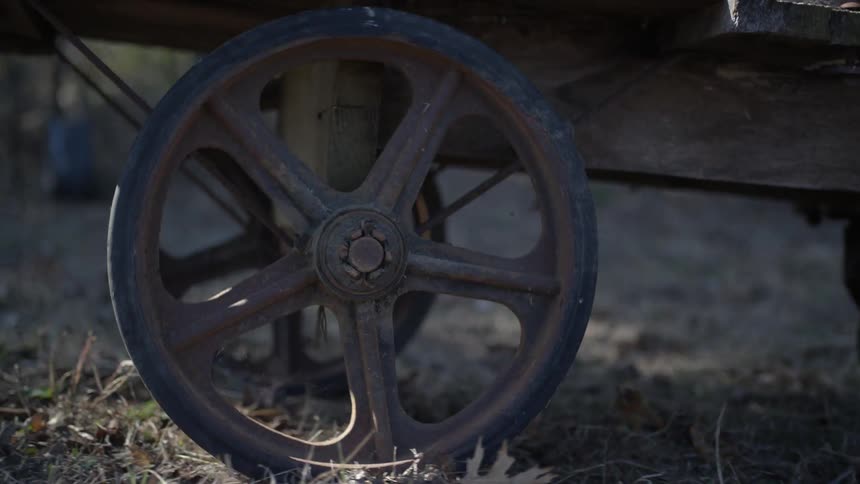 Metal wheels of a cart roll over the ground